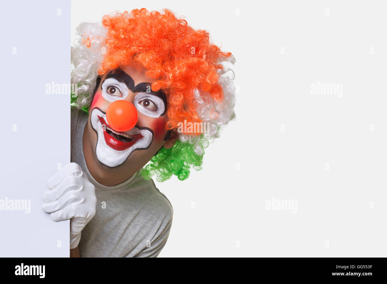 Souriante jeune femme clown smiling over white background Banque D'Images