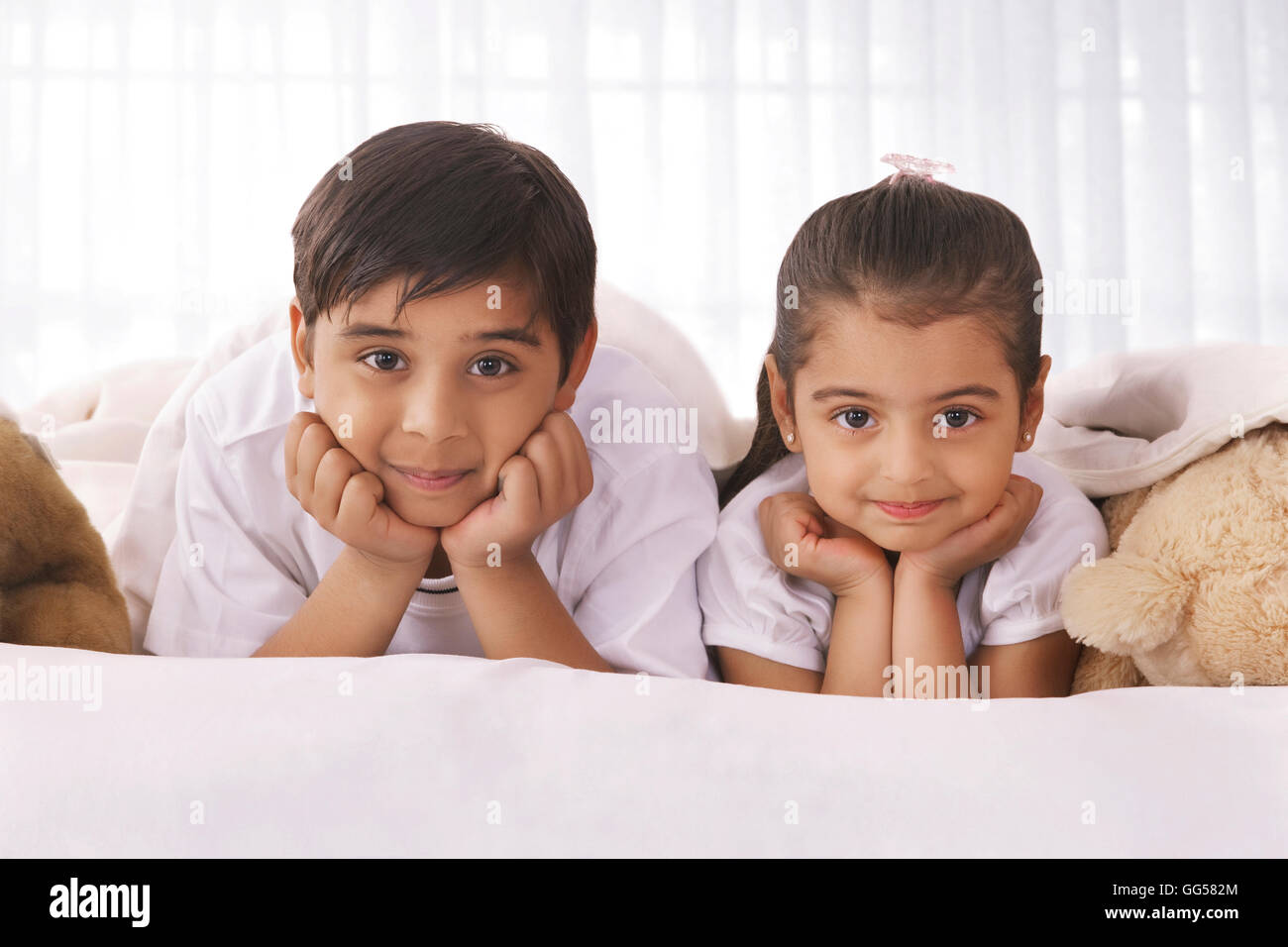 Portrait of cute siblings Lying in Bed Banque D'Images