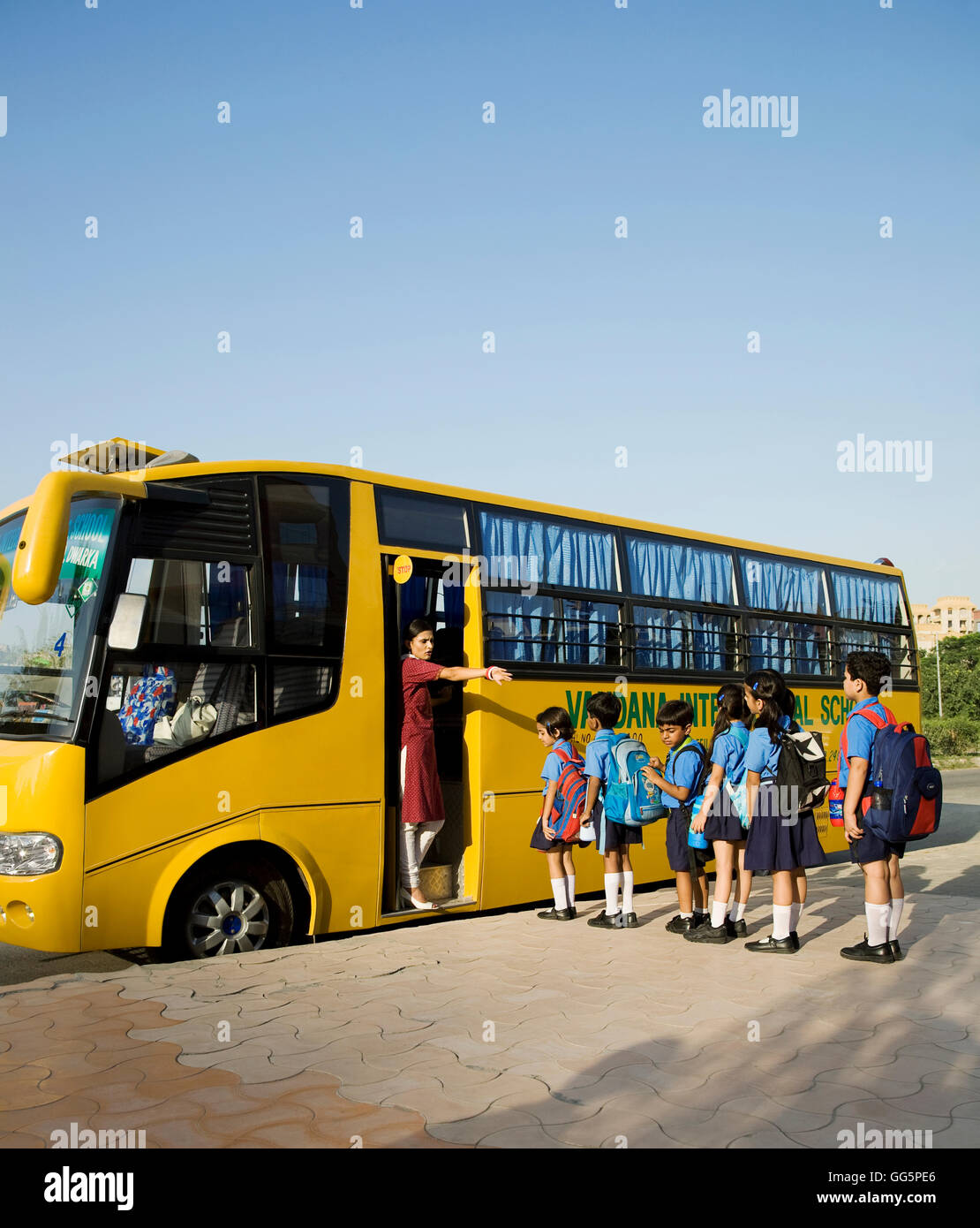Les enfants de l'école montent sur un autobus scolaire Banque D'Images