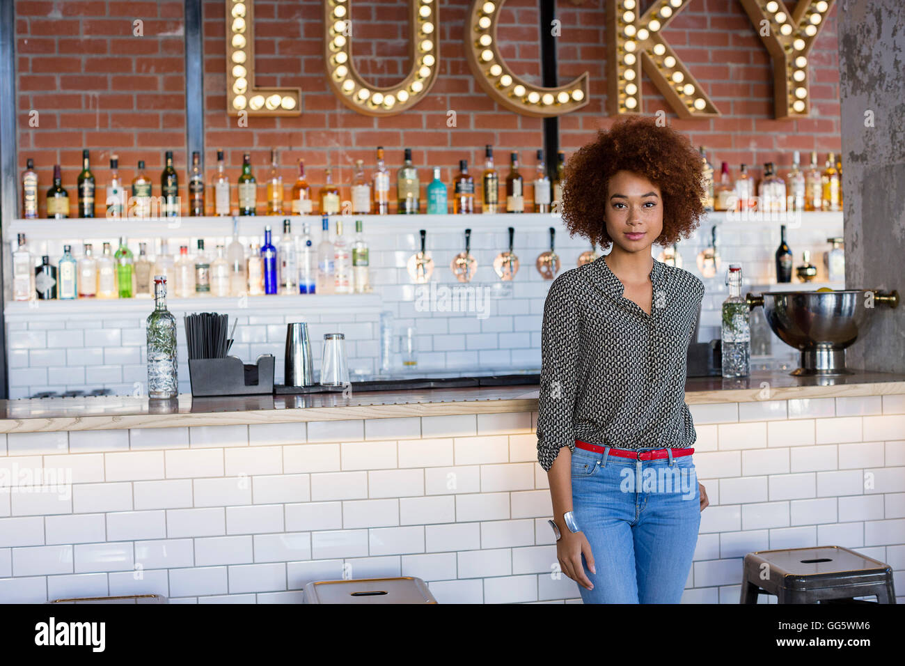 Portrait of a young woman standing at bar counter Banque D'Images