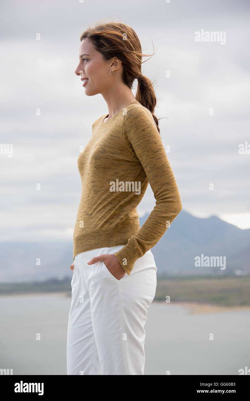 Portrait of a woman standing at lakeshore looking at view Banque D'Images