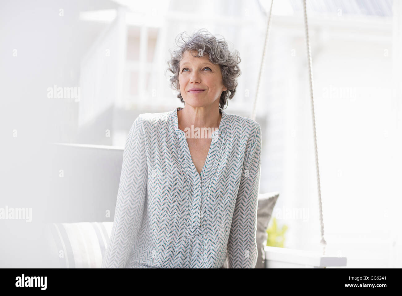 Femme assise sur une balançoire et la pensée Banque D'Images Femme assise sur une balançoire et la pensée Banque D'Images