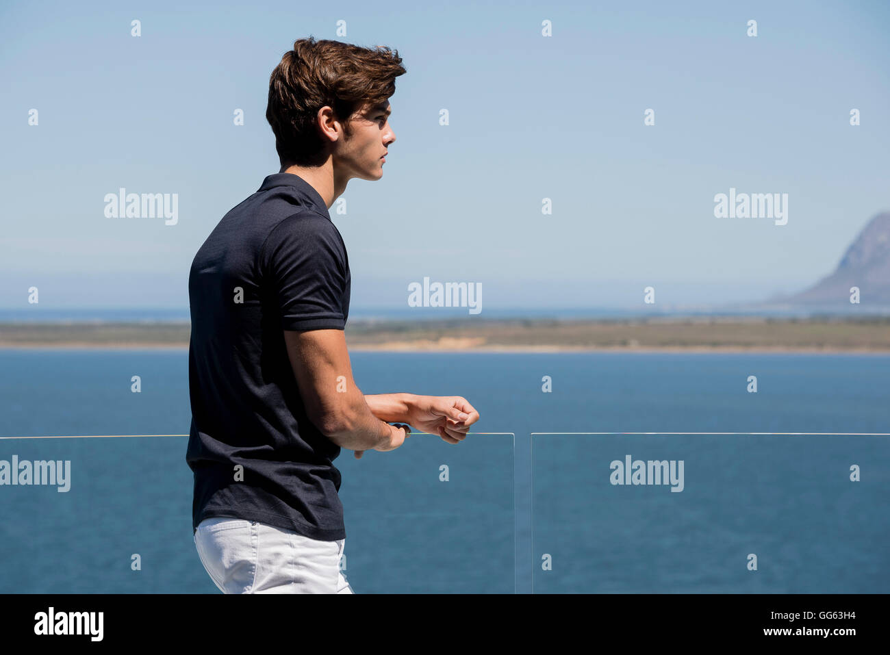 Jeune homme debout sur le balcon en plein air Banque D'Images