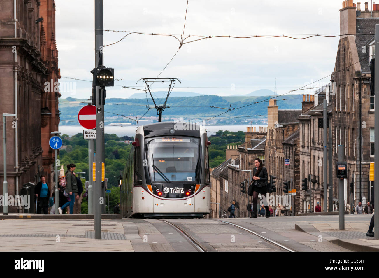 Un tramway d'Édimbourg l'approche de l'arrêt St Andrew Square, avec l'estuaire de la Forth en arrière-plan. Banque D'Images