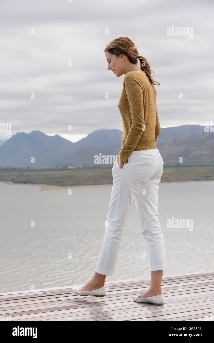 Jeune femme debout sur le pont au Lakeshore Banque D'Images
