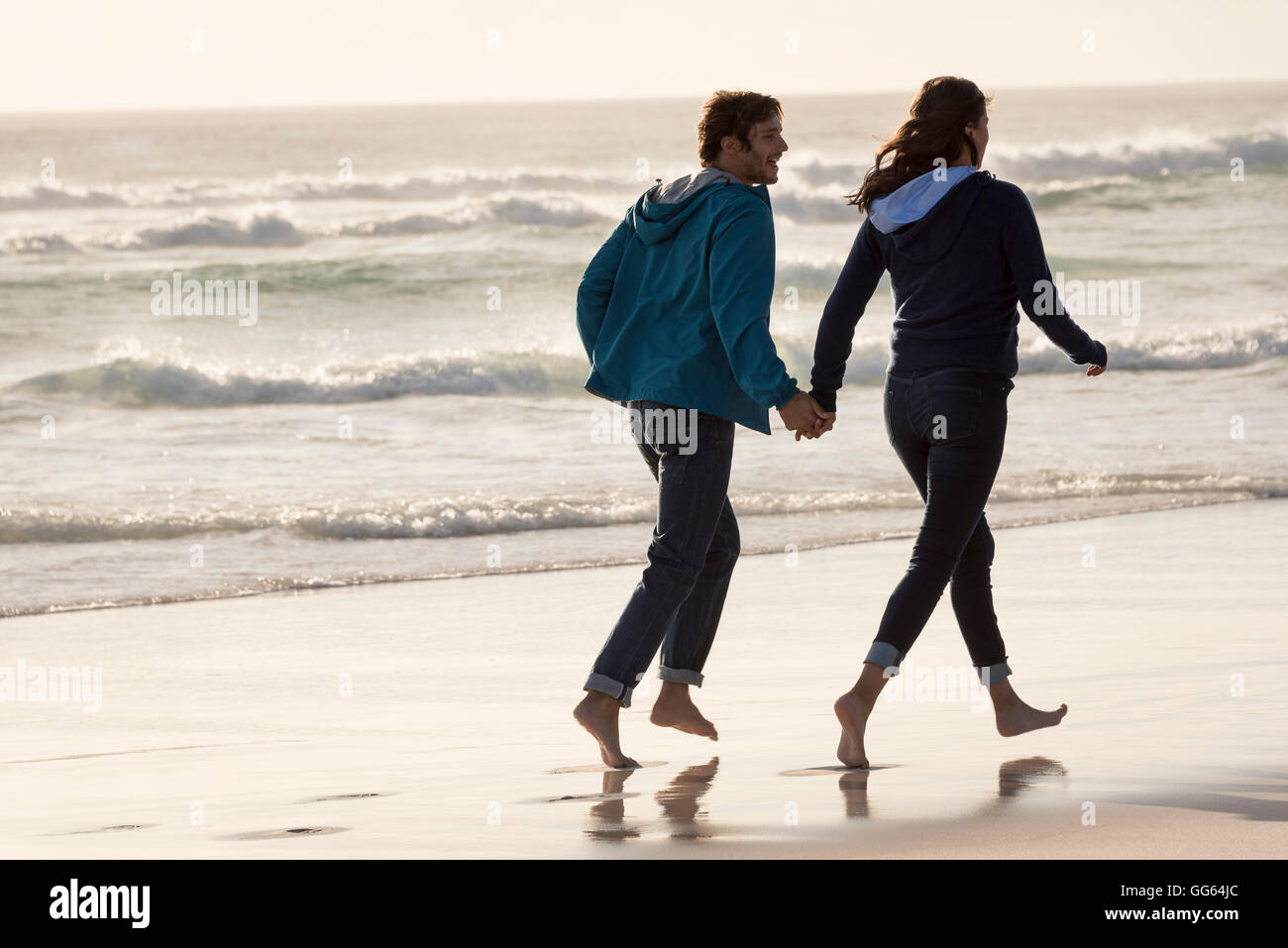 Happy young couple running on beach Banque D'Images