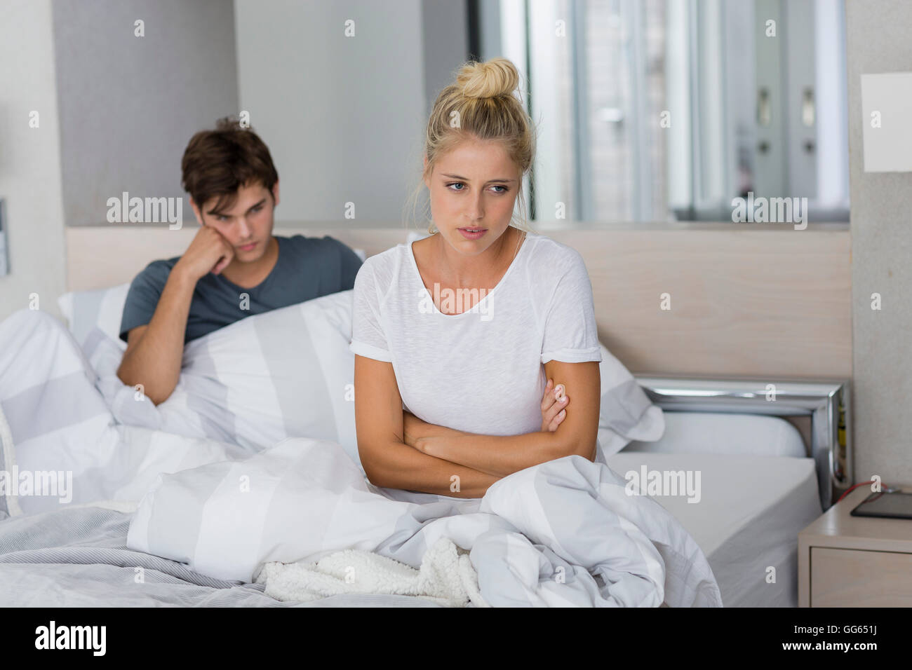 Couple assis sur le lit avec les difficultés relationnelles Banque D'Images