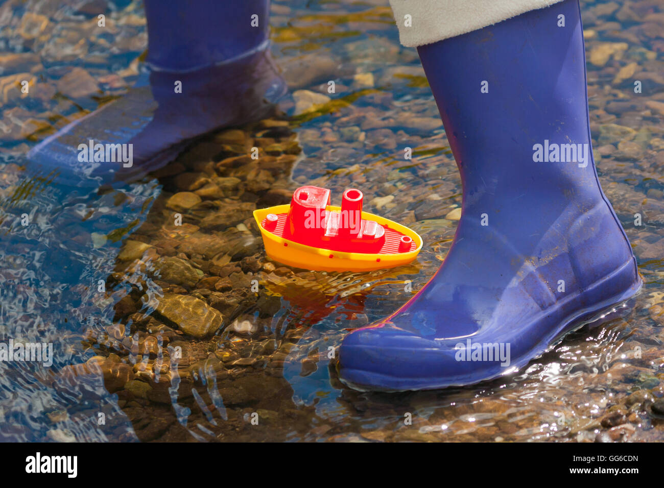 Bateau de jouets et enfants wellies Banque D'Images