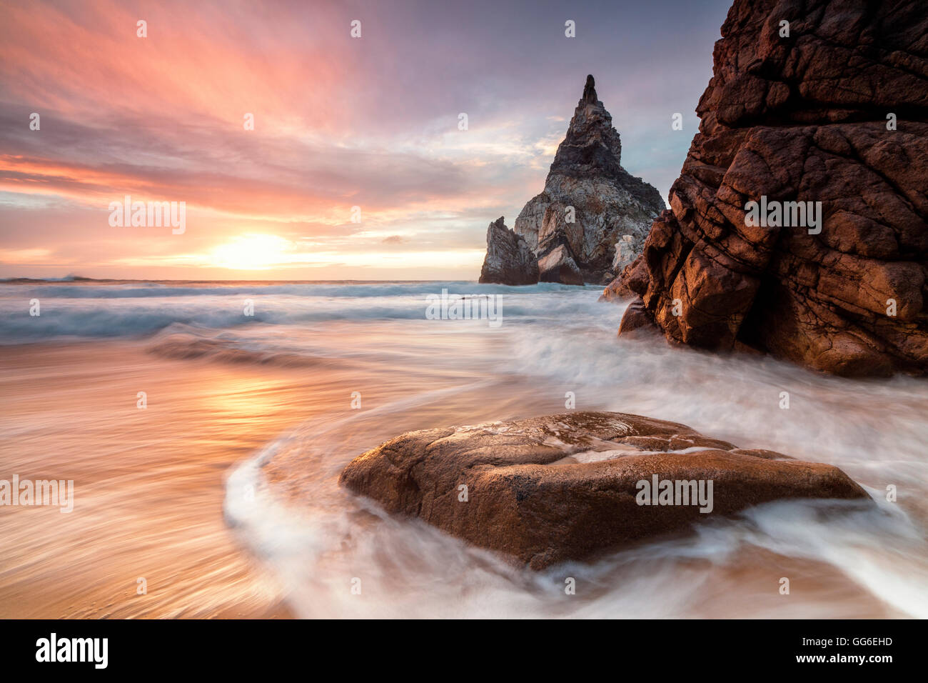 Le Fiery sky au coucher du soleil se reflète sur les vagues de l'océan et les falaises, Praia da Ursa, Cabo da Roca, Colares, Sintra, Portugal Banque D'Images