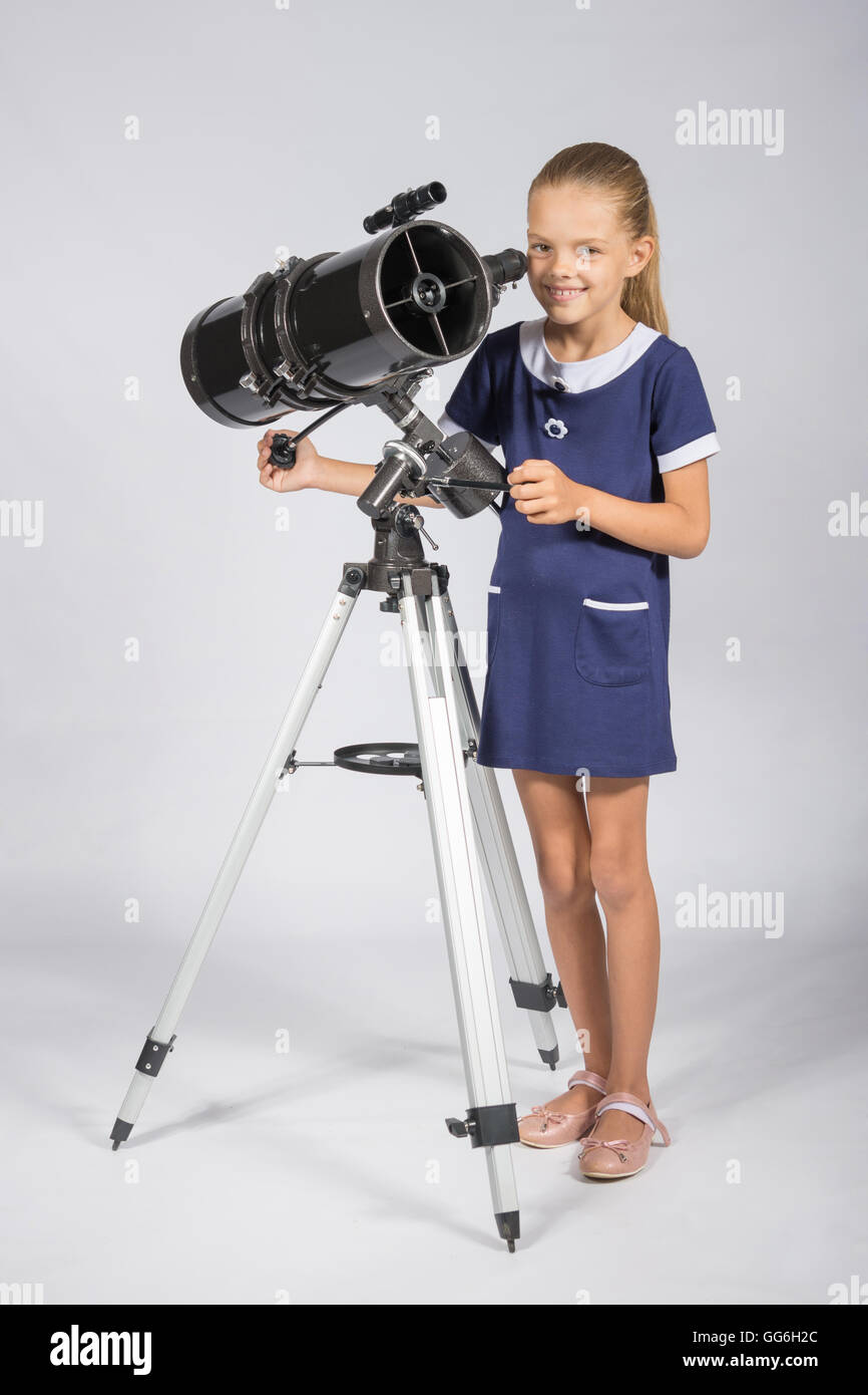 Le jeune astronome établit un télescope et regardé dans le cadre Banque D'Images