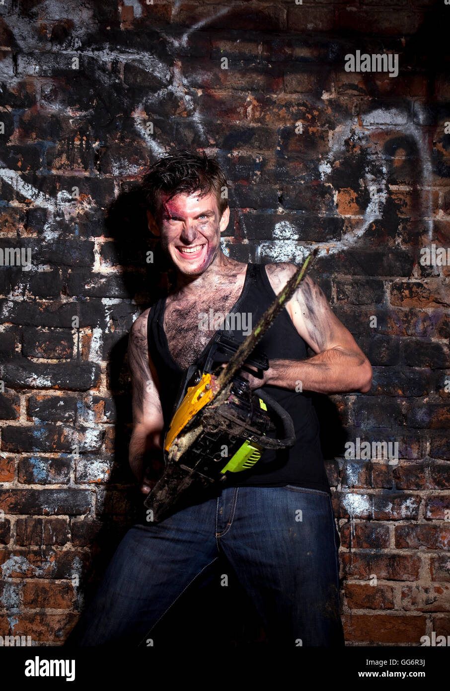 Fou horrible sur un fond sombre et scie à essence Banque D'Images