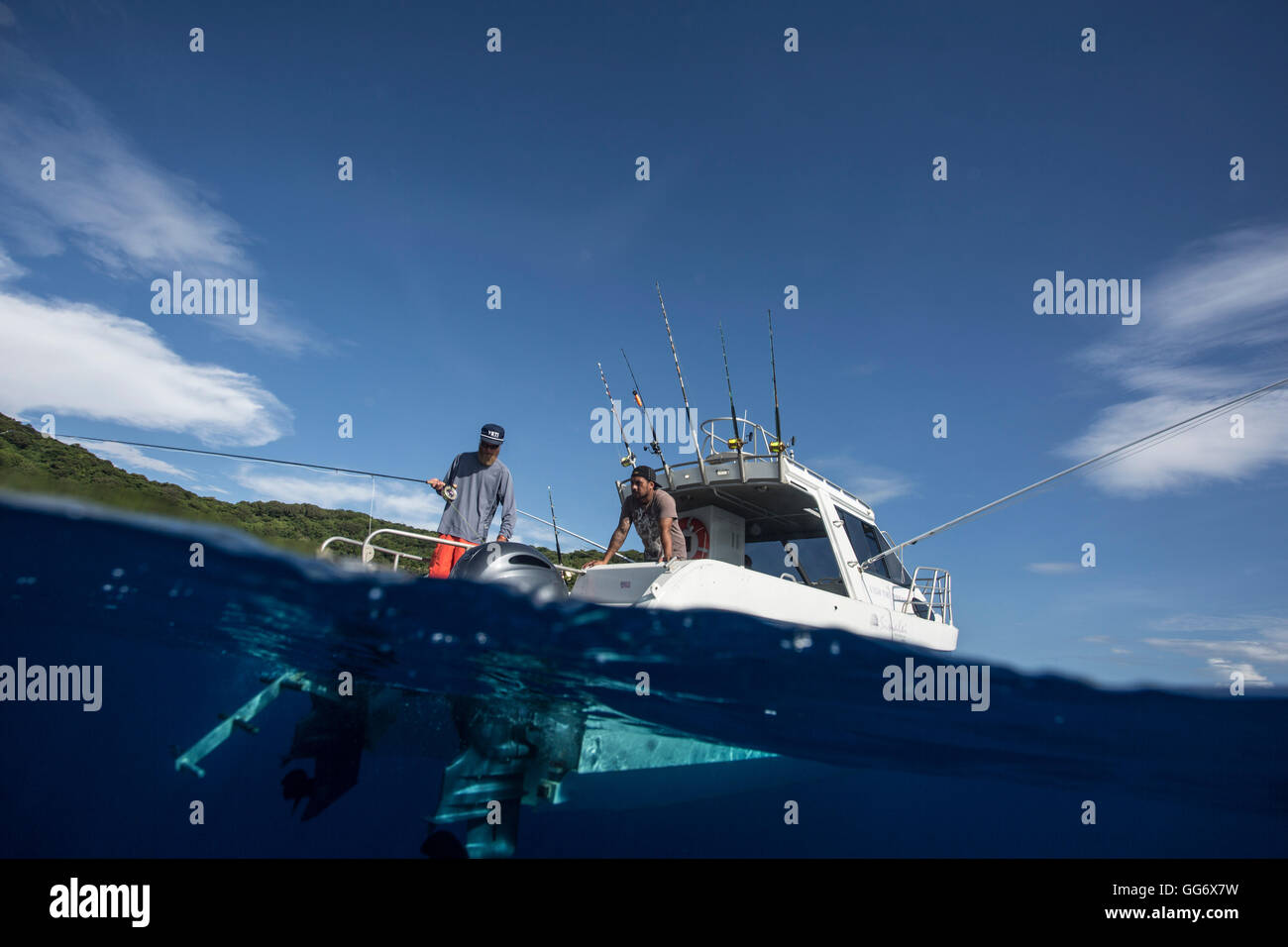 Angler Jonathan Jones et l'Aïdi voler des poissons d'un bateau au large de Samoa. Banque D'Images