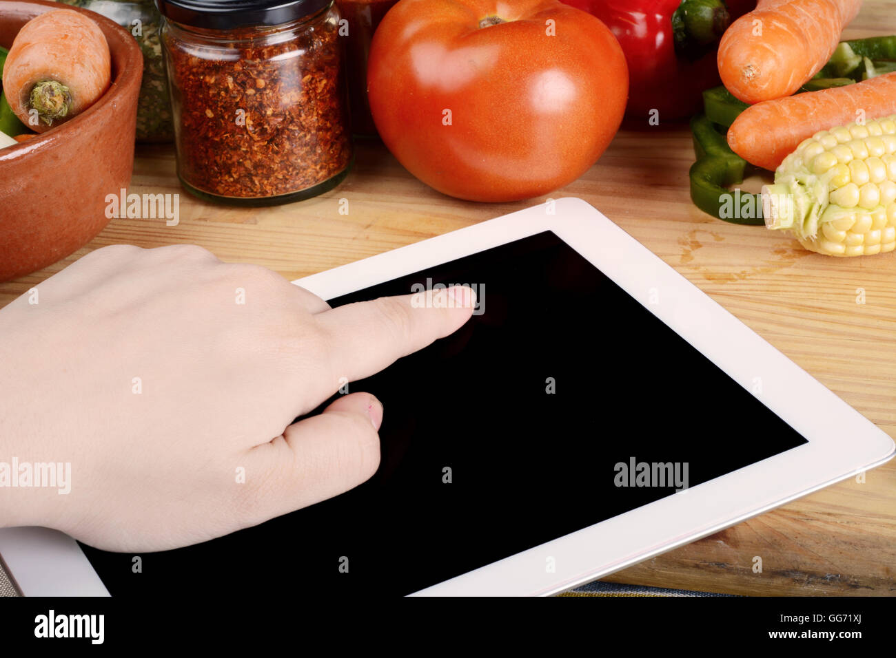 Personne de préparer des aliments à partir de la fiche sur tablette avec légumes et épices. Concept d'aliments sains. Banque D'Images