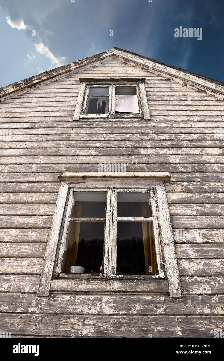 Vieille maison hantée avec deux fenêtres sombres Banque D'Images
