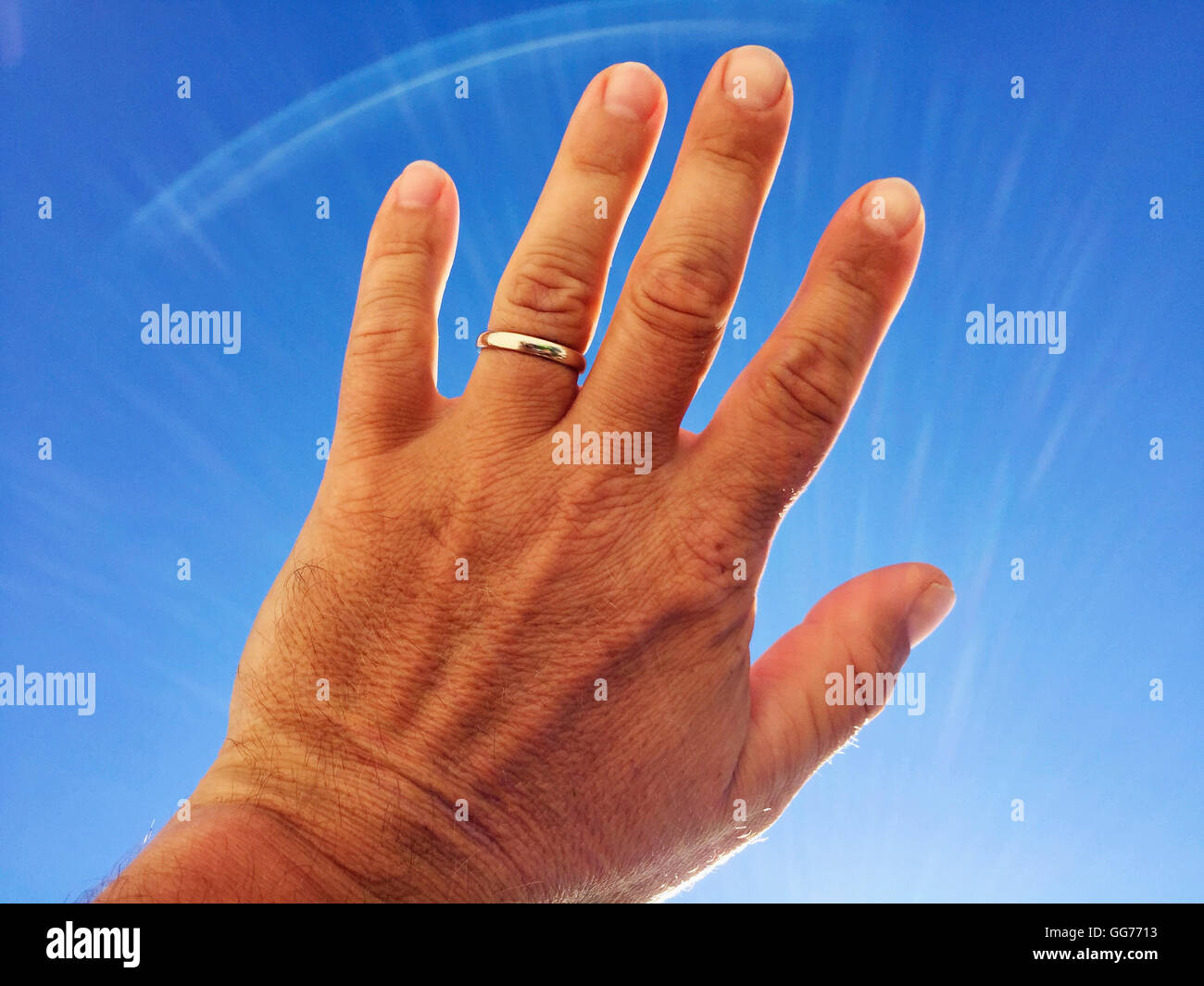 Anneau de mariage, ciel bleu, palmier, main, doigts Banque D'Images