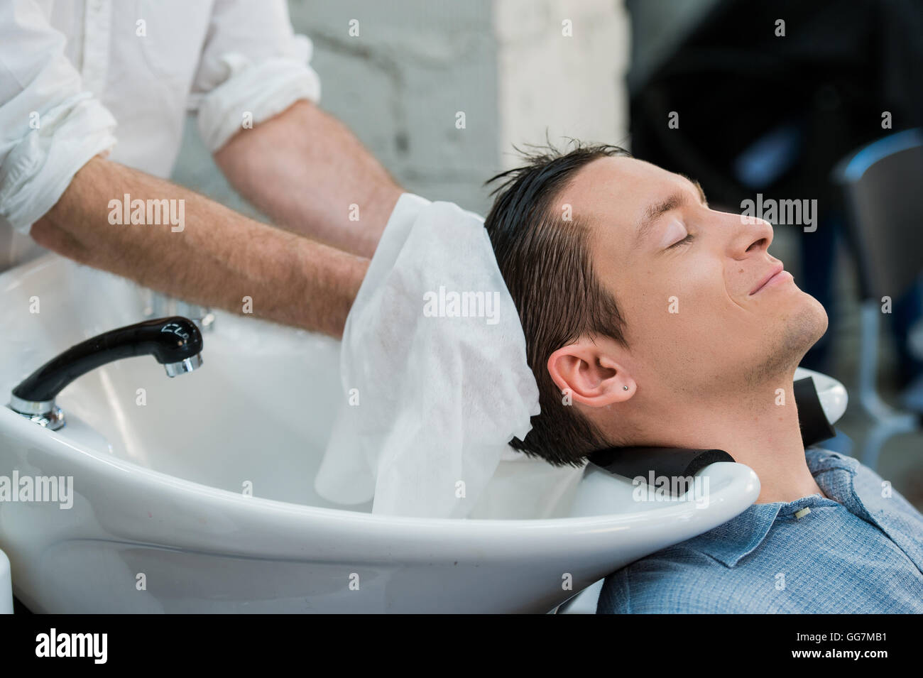 Hairstylist lave-cheveux du client dans la région de barber shop Banque D'Images