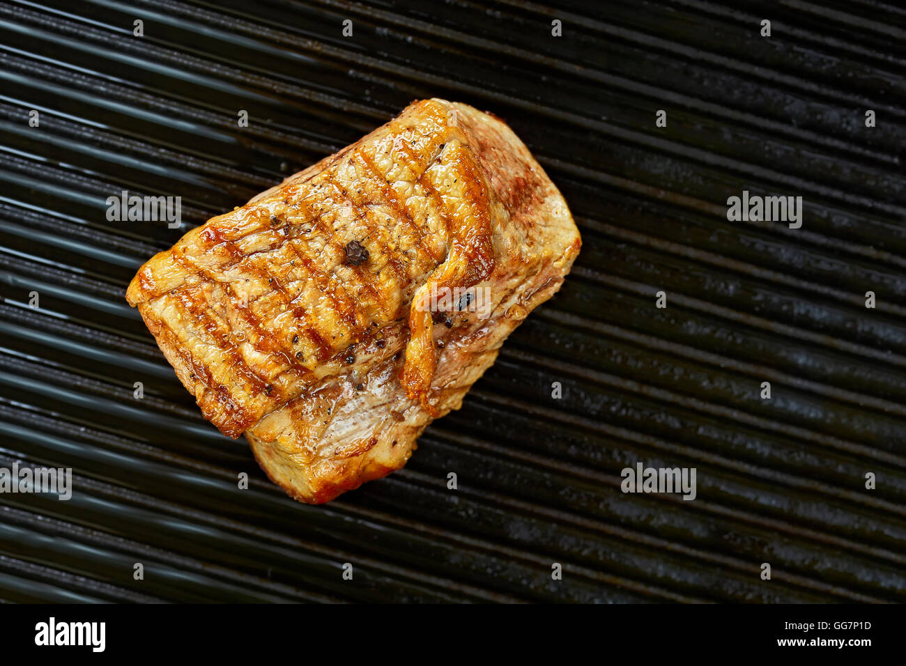 Close up photo d'une longe de porc rôti sur un pan noir. Banque D'Images