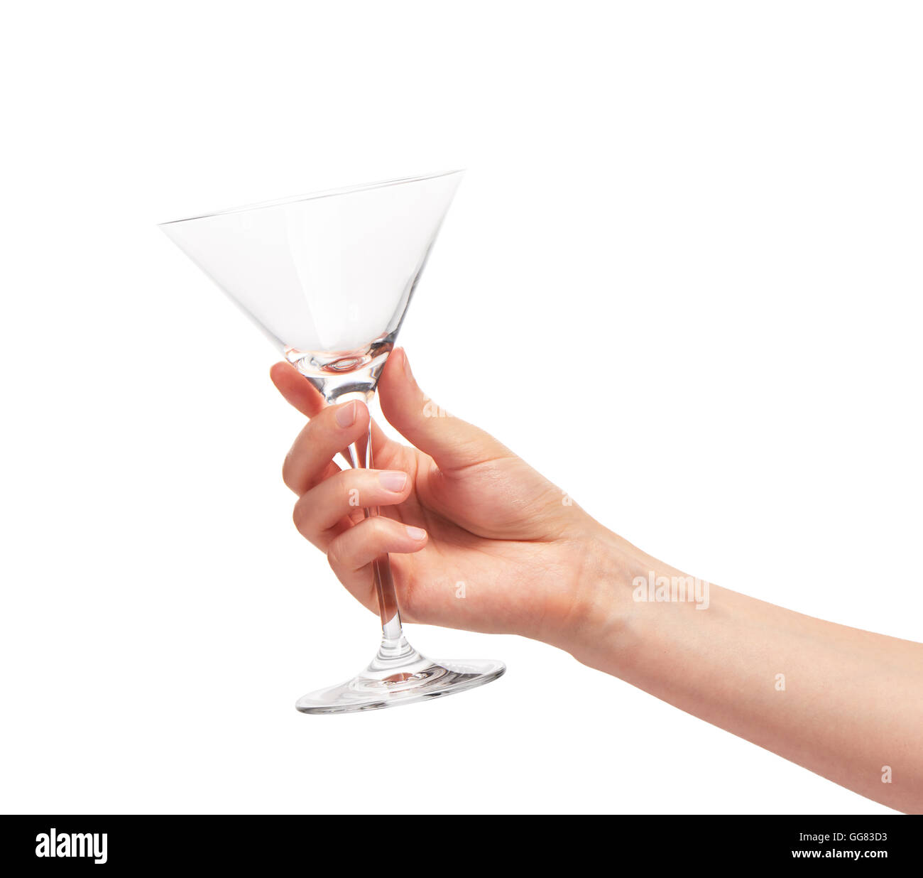 Close up of female hand holding transparent propre vide verre martini contre fond blanc. Chemin de détourage inclus Banque D'Images
