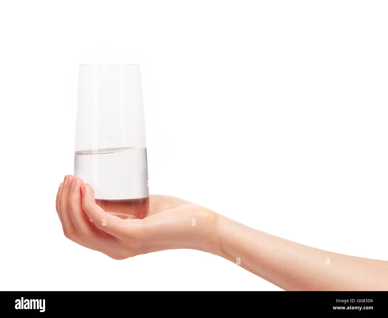 Close up of female hand holding clean transparent verre à boire avec de l'eau contre l'arrière-plan blanc. Chemin de détourage inclus Banque D'Images