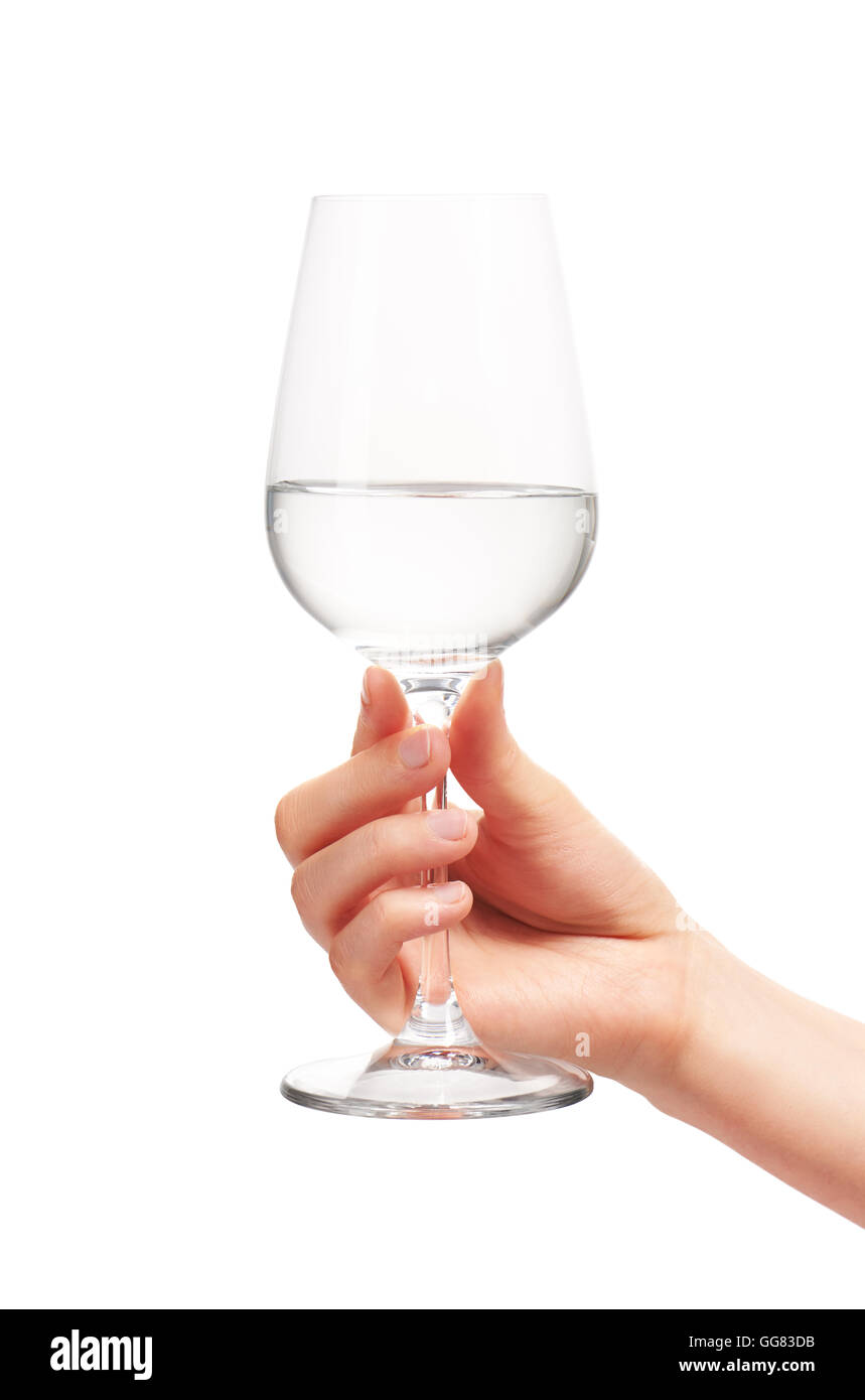 Close up of female hand holding nettoyer avec de l'eau transparent verre de vin contre l'arrière-plan blanc. Chemin de détourage inclus Banque D'Images