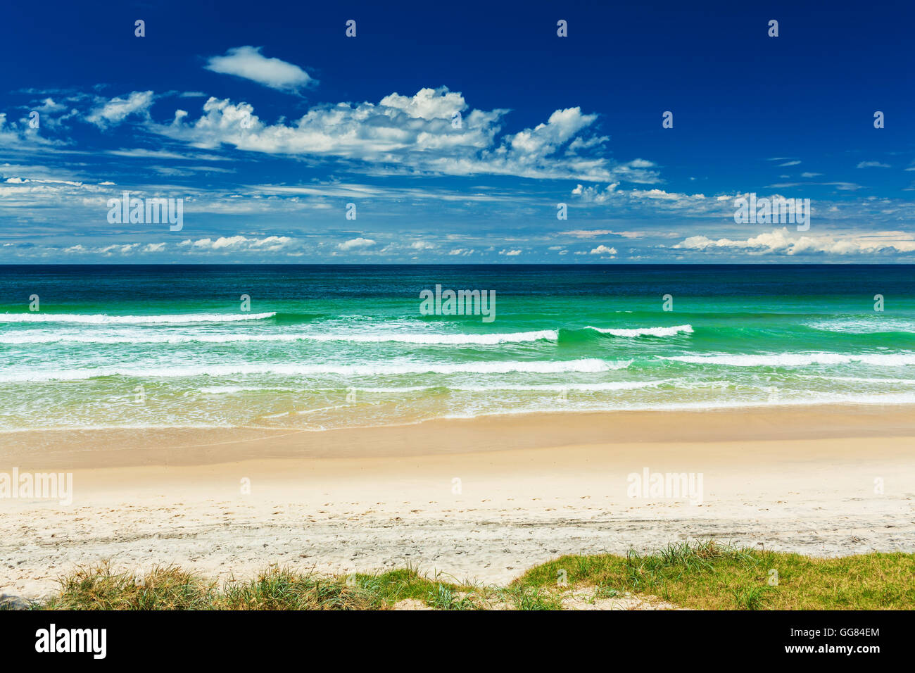 Plage vide avec piste en herbe et de vagues déferlantes, Gold Coast, Australie Banque D'Images
