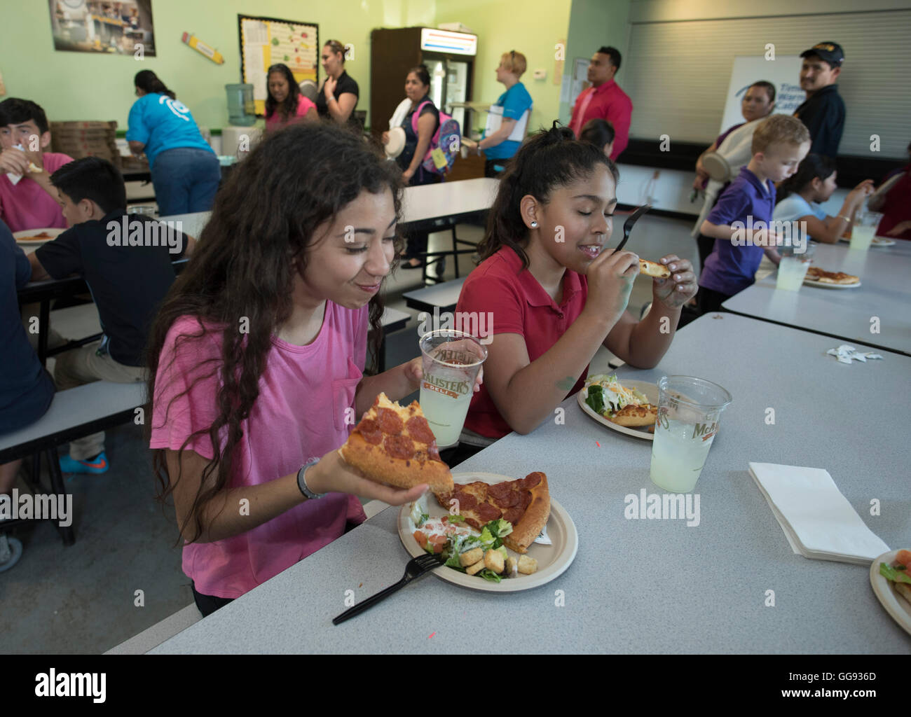 Pour manger une pizza dans la cafétéria pendant l'activité parascolaire à l'école moyenne à Austin, Texas Banque D'Images