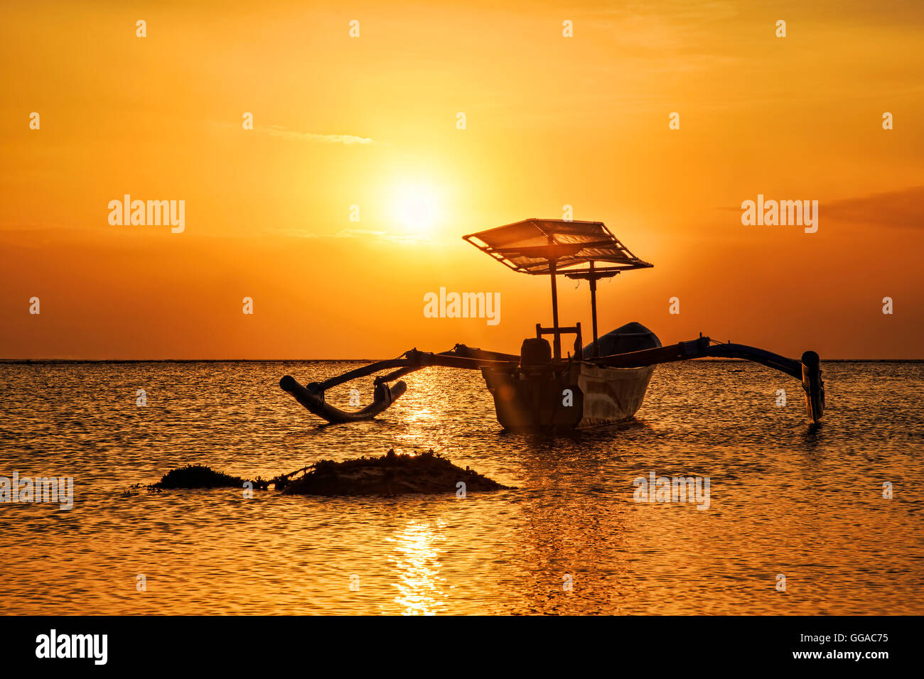 Bateau sur la plage au coucher du soleil Banque D'Images