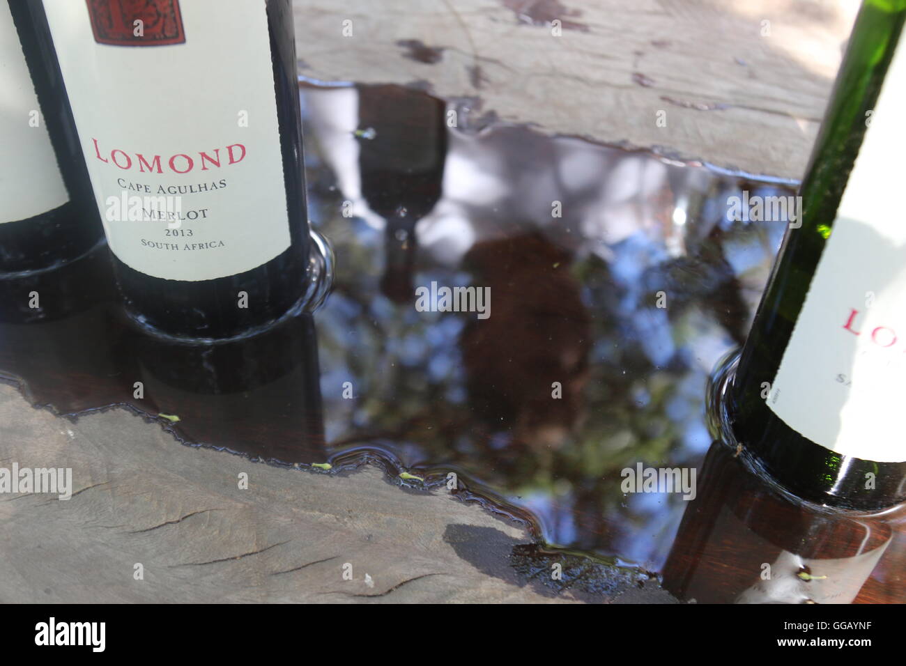 Bouteilles sur une table debout dans l'eau à Lomond Wines, cap Agulhas, Afrique du Sud Banque D'Images