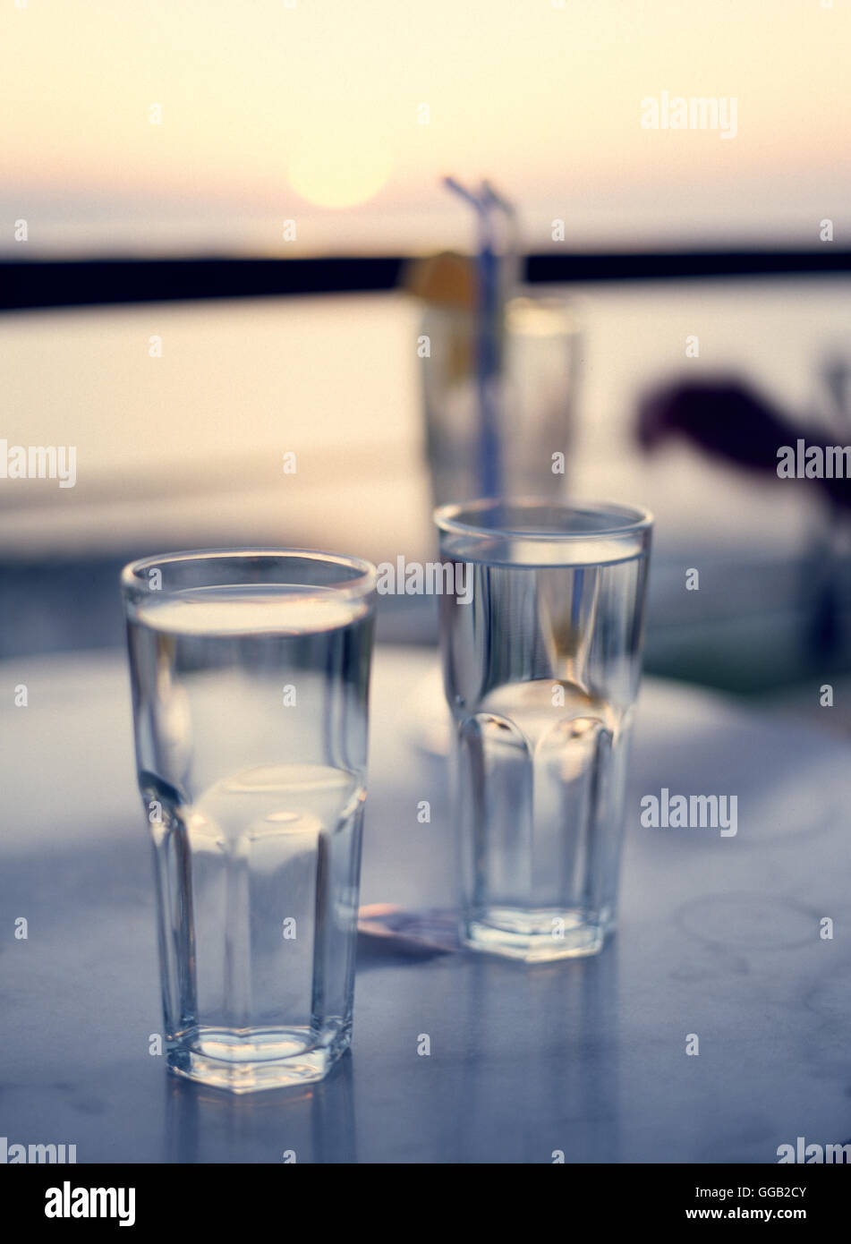 Deux verres d'eau au restaurant sur le toit avec vue sur mer, romantique coucher de soleil colorés Banque D'Images