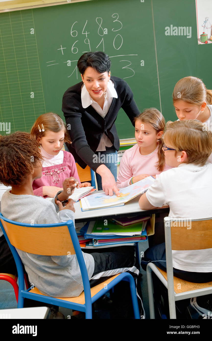 Portrait de schoolkids diligents et leur professeur parler at lesson Banque D'Images