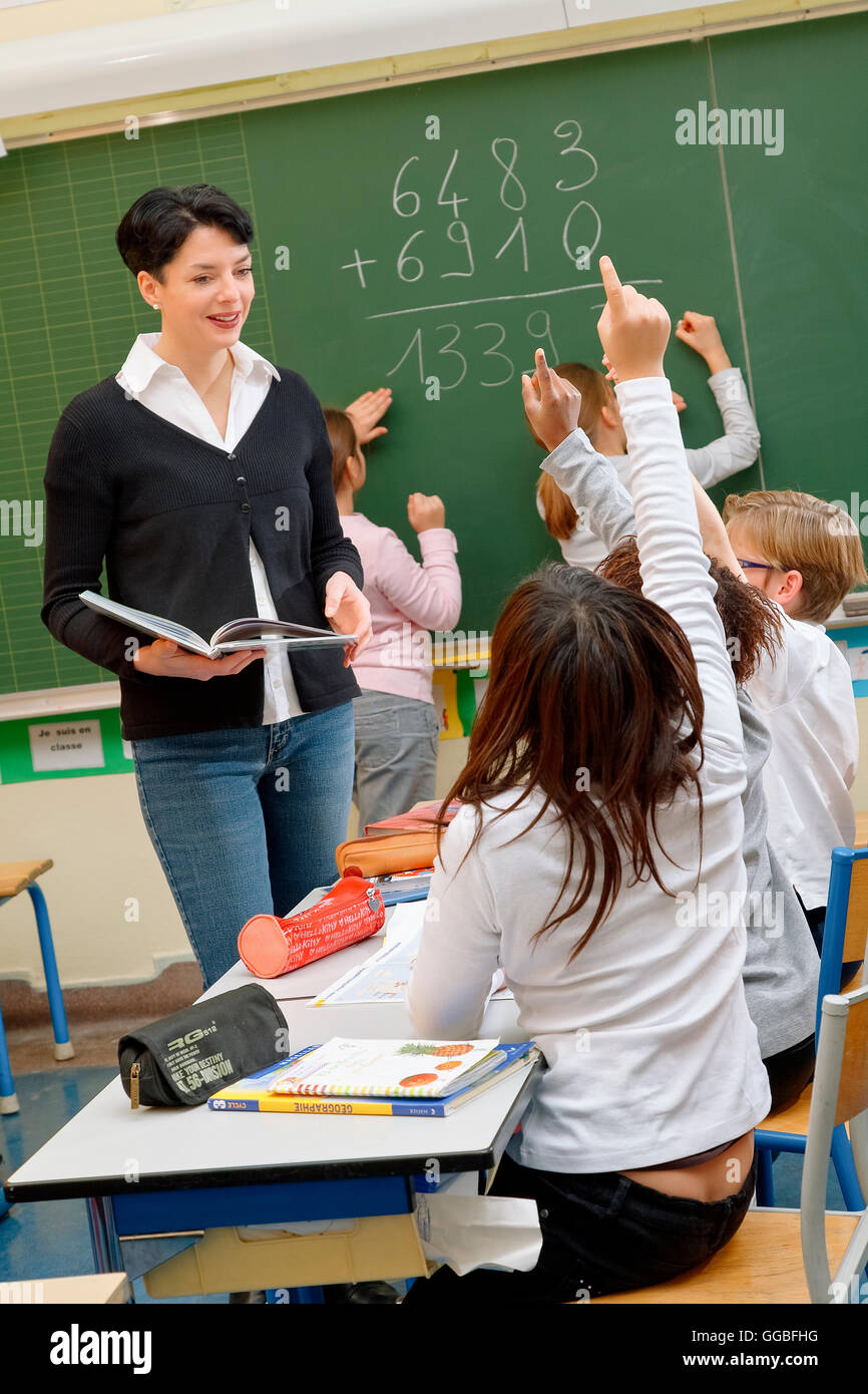 Portrait de schoolkids diligents et leur professeur parler at lesson Banque D'Images
