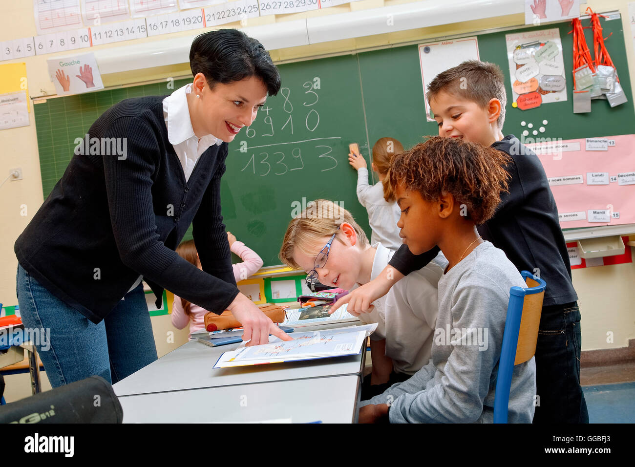 Portrait de schoolkids diligents et leur professeur parler at lesson Banque D'Images