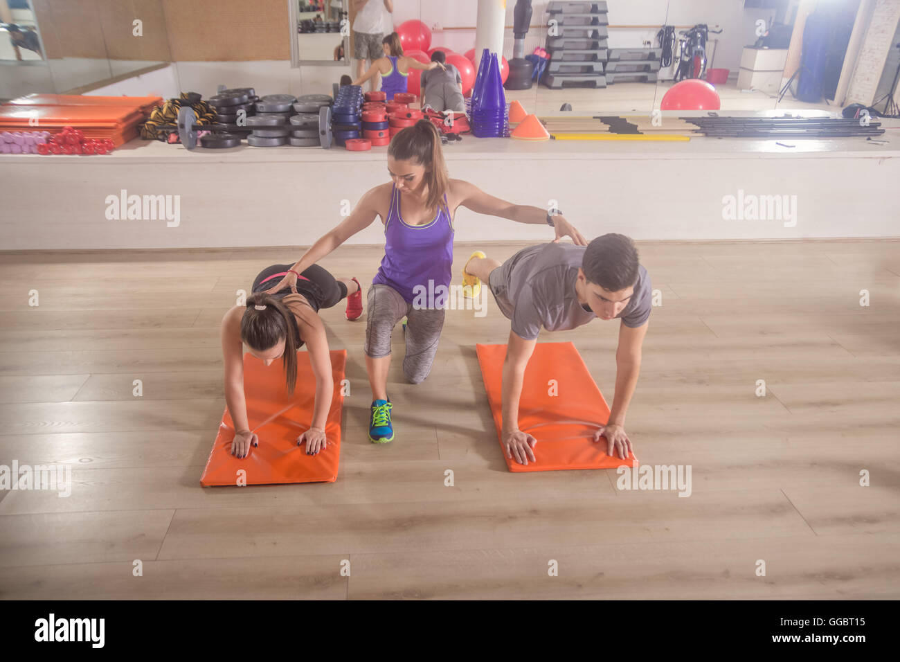 La formation d'un instructeur de conditionnement physique corriger push up groupe trois personnes sport Banque D'Images