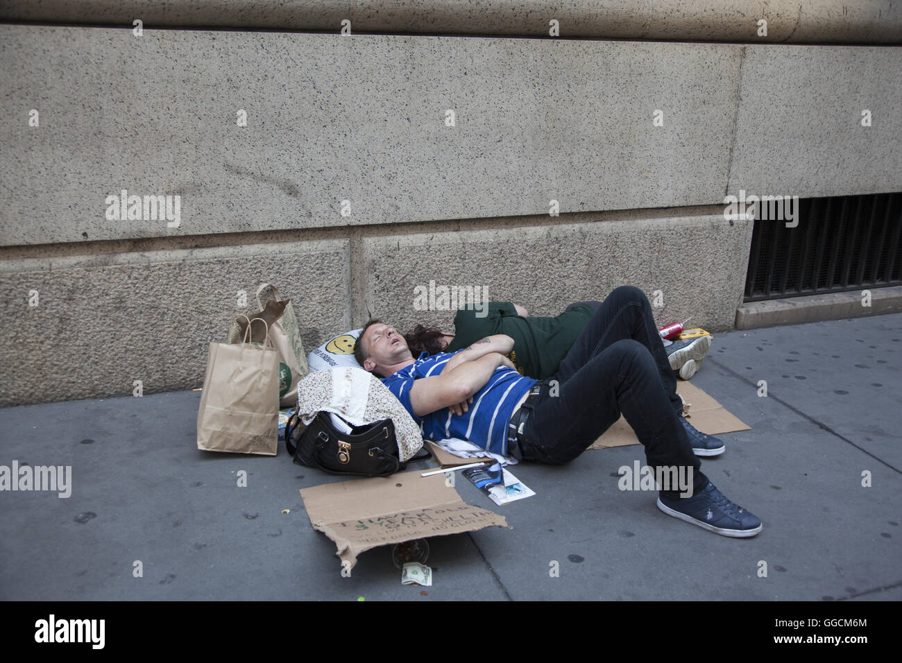Couple sommeil et demander de l'aide sur la rue à Midtown Manhattan, New York. Banque D'Images