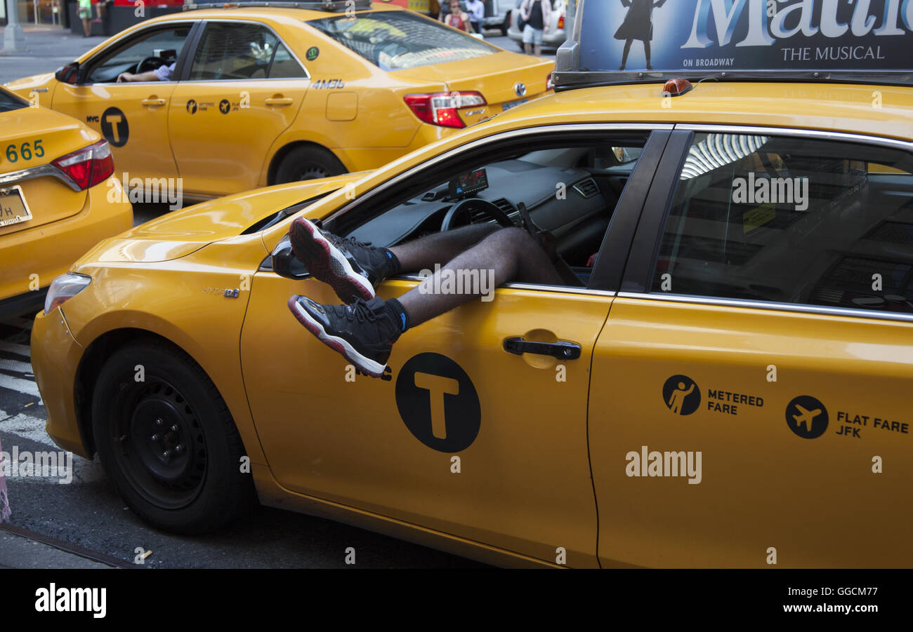 C'est chauffeur de taxi à l'arrêt de la lumière sur la 7e Avenue à Times Square sur une chaude journée d'été. NYC. Banque D'Images