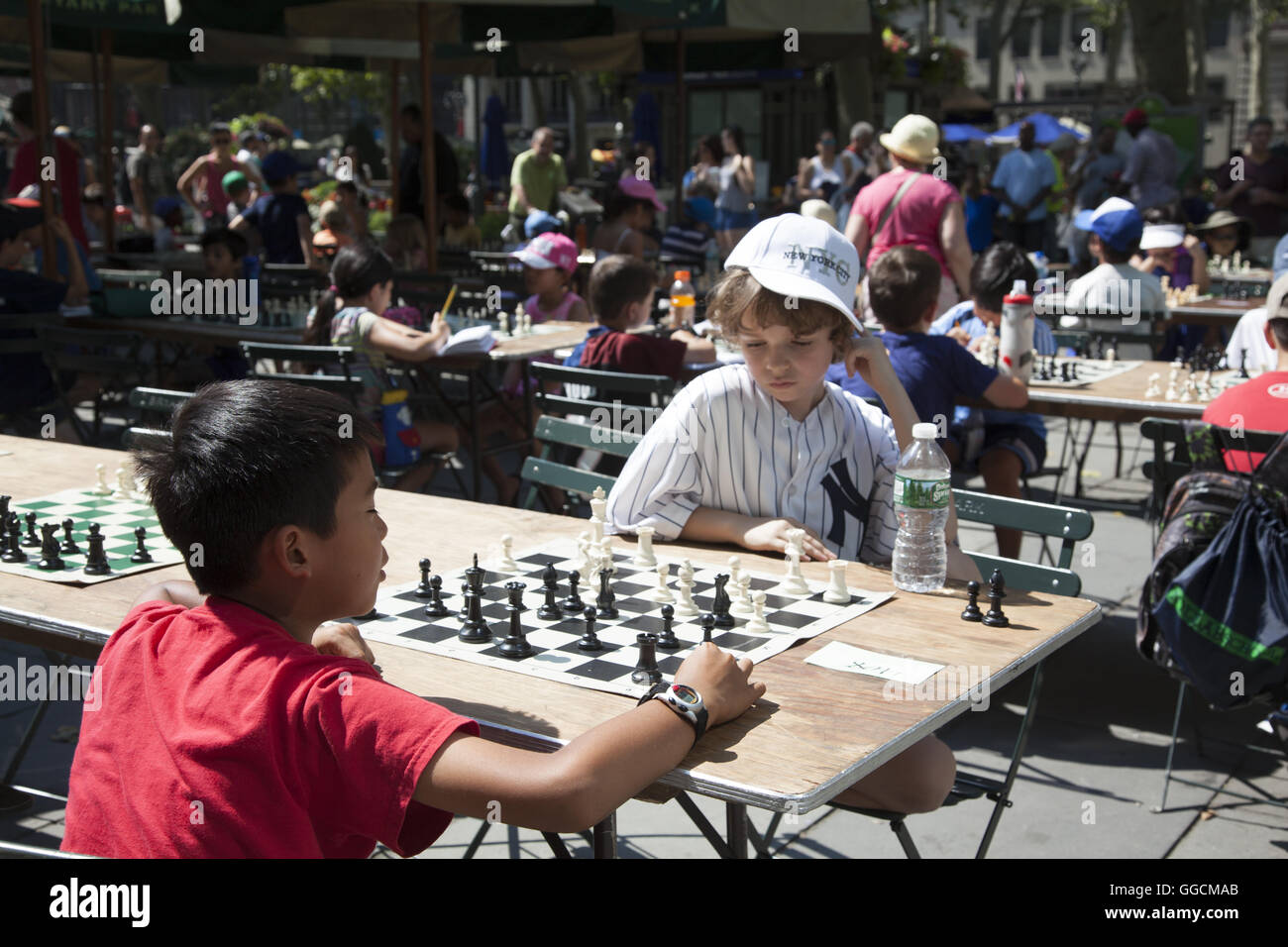 Les enfants à apprendre et jouer aux échecs à l'occasion d'une journée d'échecs (camp) dans Bryant Park à Manhattan, New York. Banque D'Images