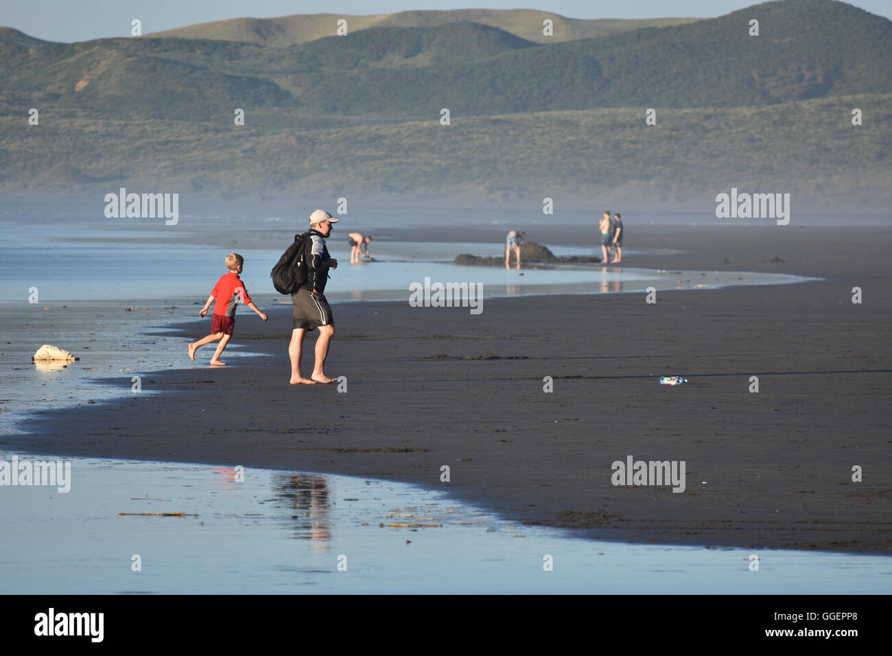 Raglan NZ à marée basse plage famille Banque D'Images