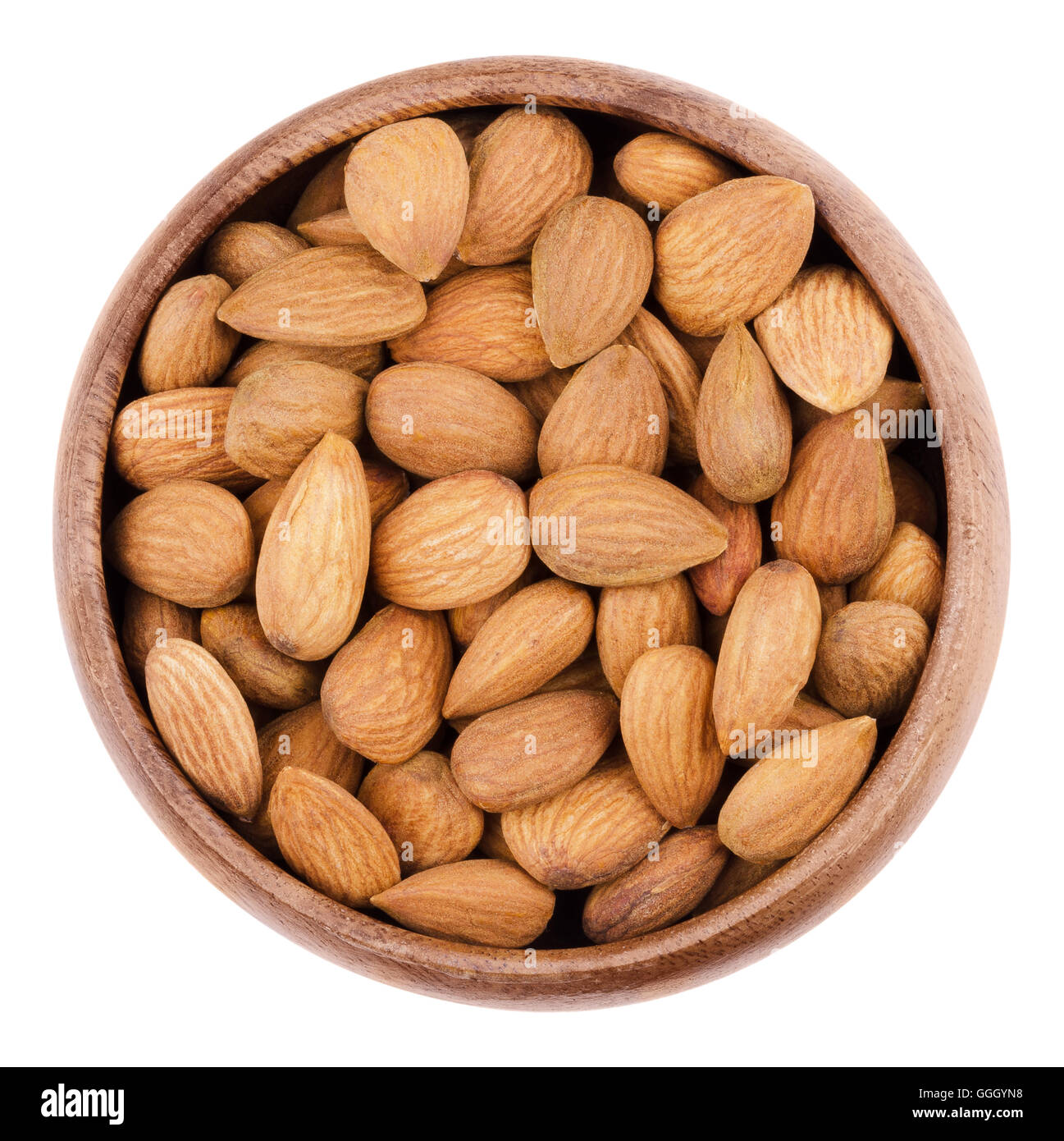 Les amandes dans un bol sur fond blanc. Les matières premières graines comestibles ne sont pas des noix, ils sont botaniquement drupes. Banque D'Images