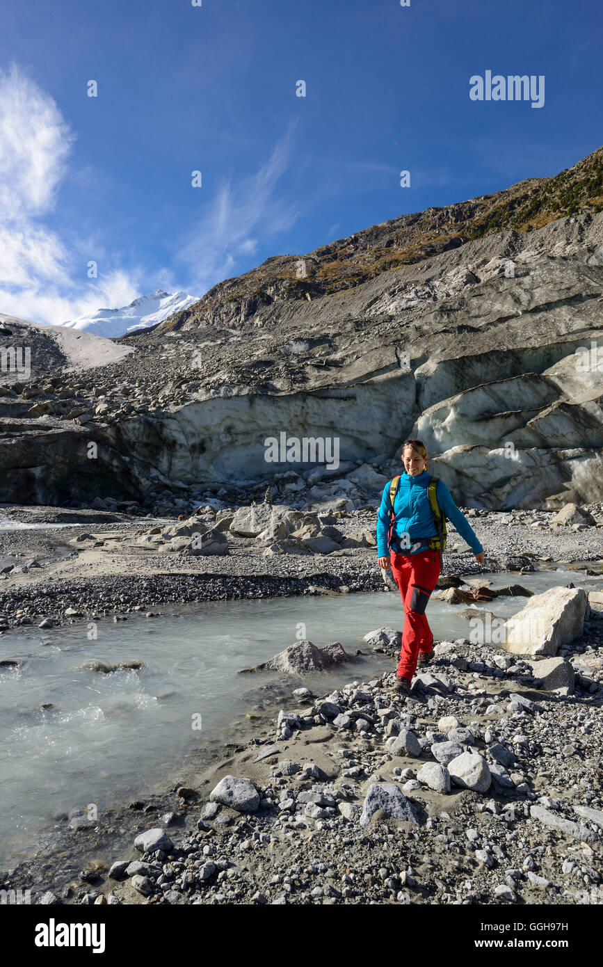 Femme traversant le glacier Morteratsch Creek, près de l'embouchure du glacier Morteratsch avec vue sur le Piz Bernina (4049 m), l'Engadine, G Banque D'Images