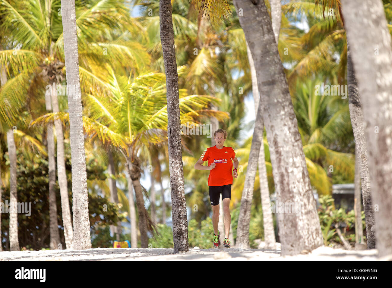 Jeune homme qui court le long de la plage bordée de palmiers, la Dominique, Lesser Antilles, Caribbean Banque D'Images