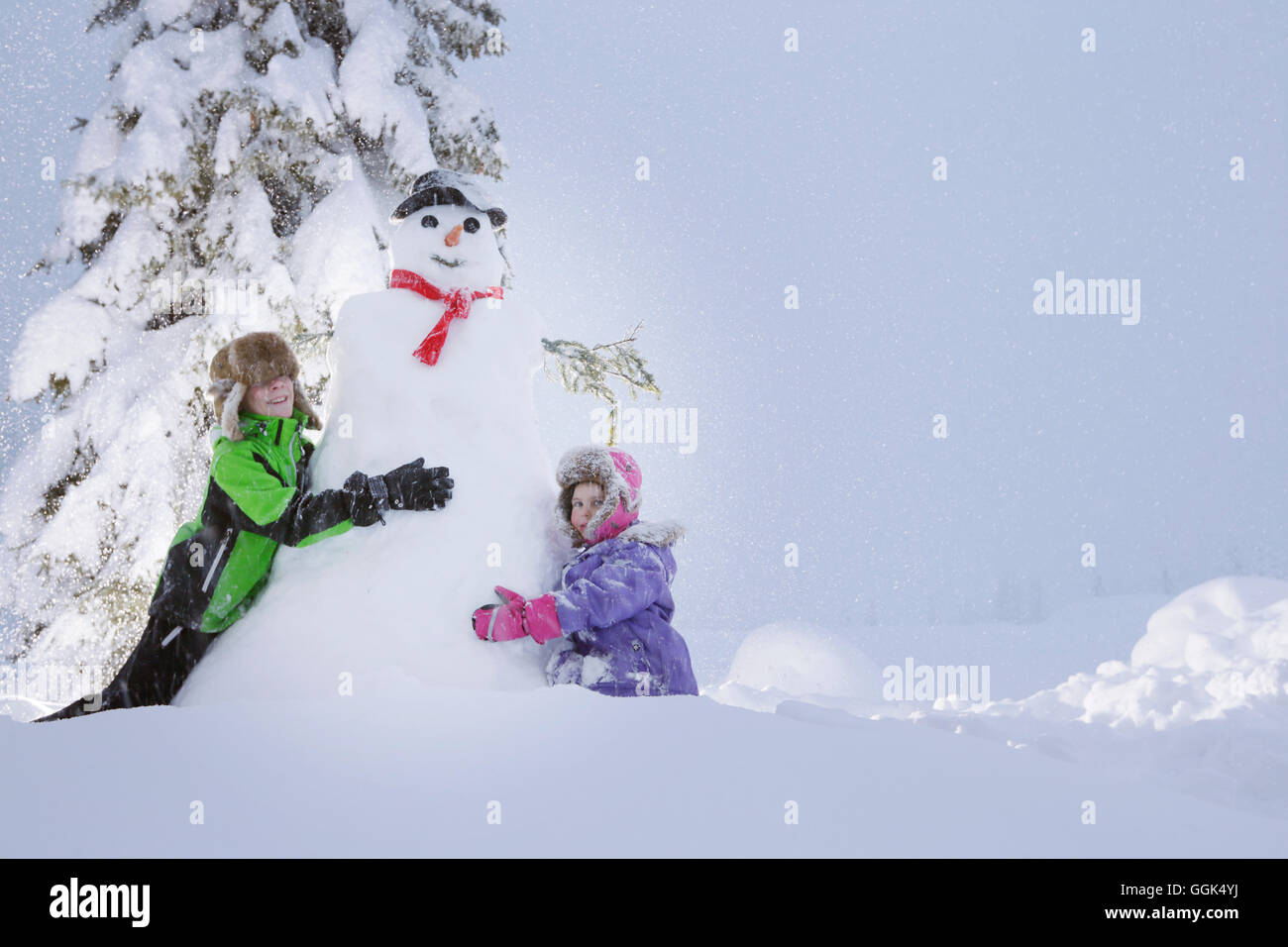 Les enfants faire un bonhomme de neige, Passo Monte Croce di Comelico, Tyrol du Sud, Italie Banque D'Images
