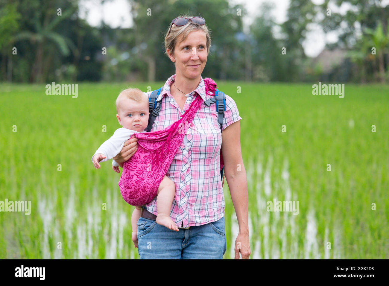 Mère avec son enfant, porte-bébé, l'envelopper, dans un champ de riz, riz, sourire, campagne, vacances en famille en Asie, le congé parental, Germa Banque D'Images