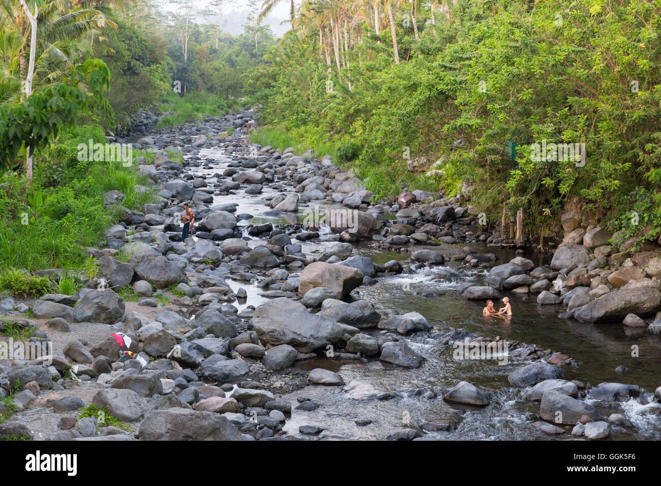 Père et fils en prenant un bain dans une rivière, rivière, rochers, pierres, des bains locaux prenant balinais ici, les arbres, la coutume locale, intercu Banque D'Images