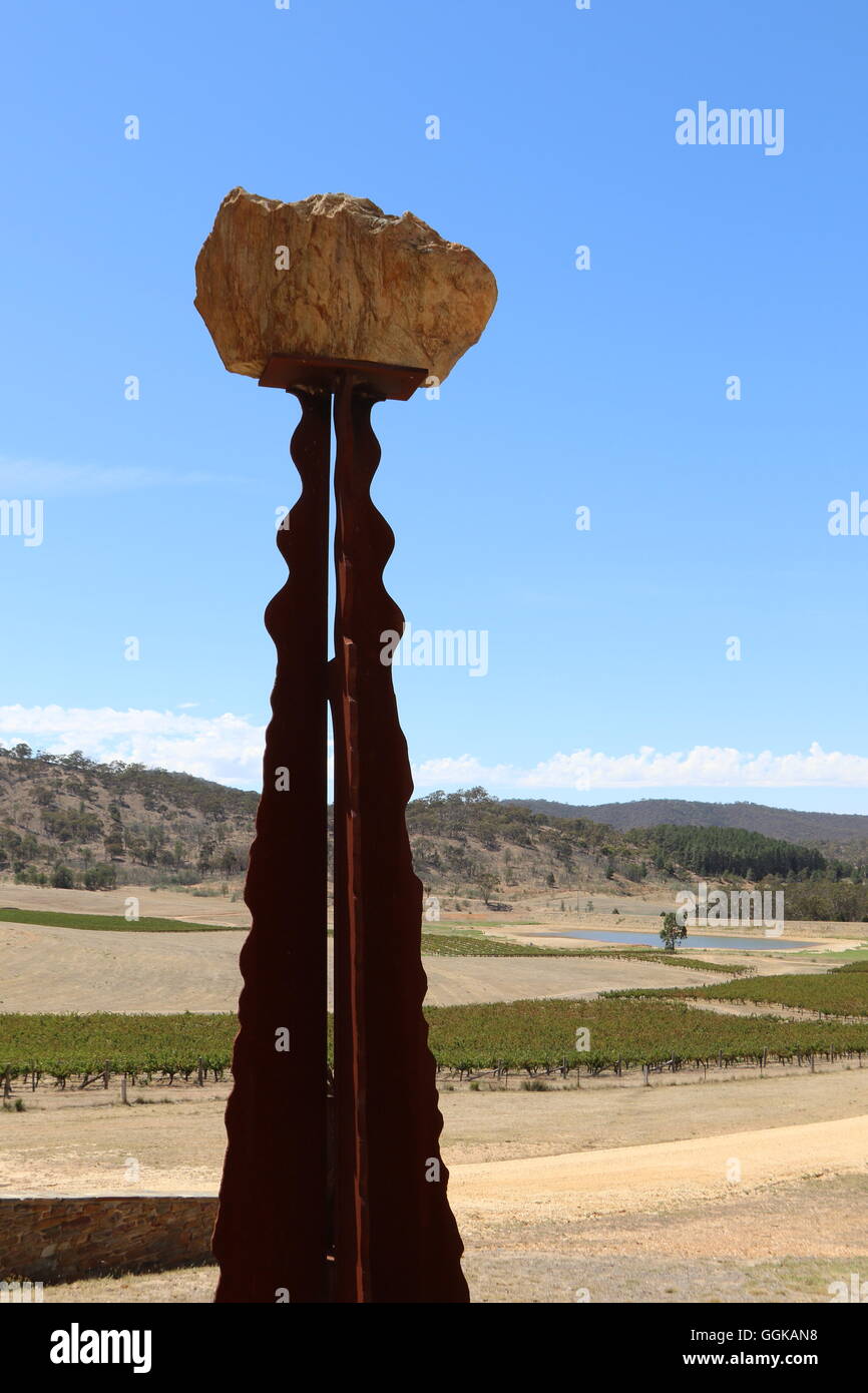 Rock sur un poteau avec vignes et montagnes à l'arrière à Dalwhinnie Vins, Pyrénées, Moonambel, Australie Banque D'Images