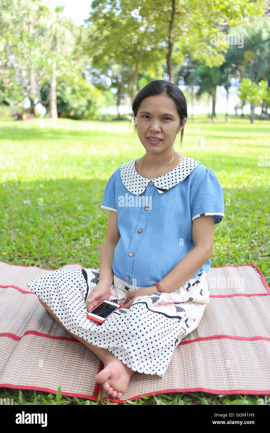 Femme enceinte est asiatique, dans le parc de loisirs et est fait esprit brillant parce qu'il fait bon bébé en bonne santé. Banque D'Images