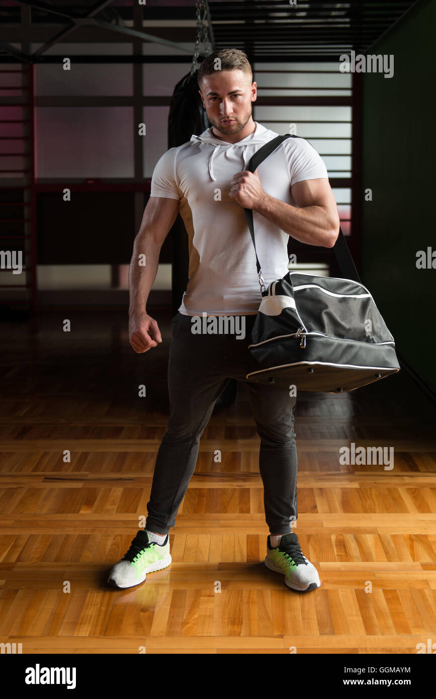 Jeune homme fit avec sac de sport passe le in gym Banque D'Images