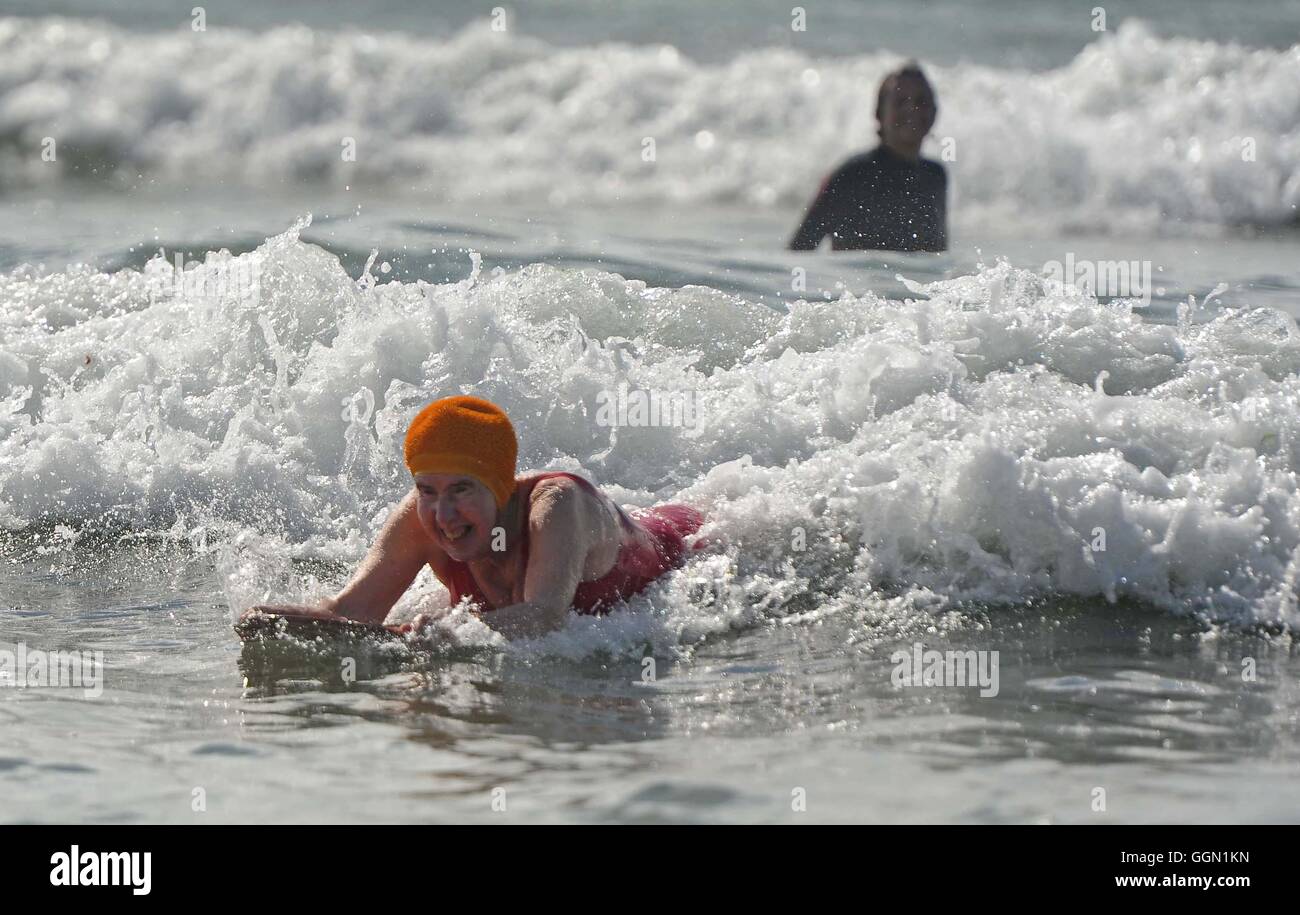 Femme âgée bénéficie d'bodyboard à la plage de Polzeath, Cornwall, UK Banque D'Images