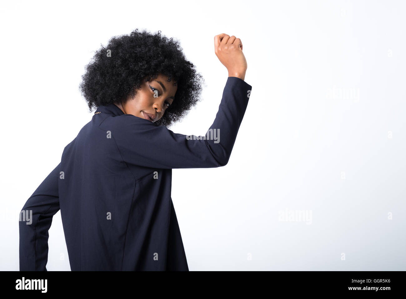 Un jeune modèle afro-caribéen crée des formes amusantes lors d'une séance de mode avec un espace de copie à droite du cadre Banque D'Images