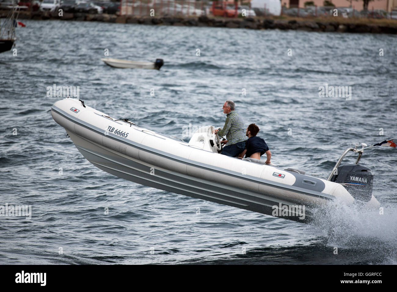 Deux hommes sur bateau de haut vol au-dessus des vagues Banque D'Images