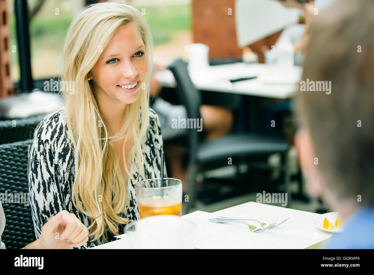Smiling Caucasian woman sitting at table Banque D'Images